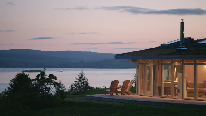 Elevated house illuminated at twilight overlooks scenic Sound of Mull Scotland