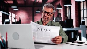 Businessman Reading Newspaper At Office Desk At Work - Powered by Shutterstock - Get 15% off with code: PIKWIZARD15