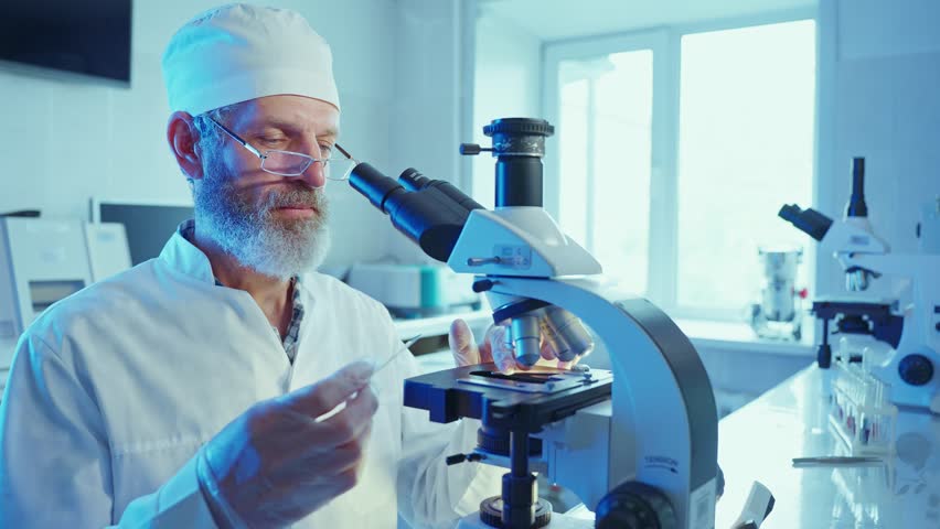 A chemist conducts analysis using advanced laboratory equipment, focusing on chemical samples under a microscope.