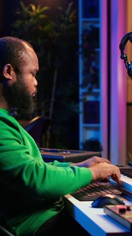 Vertical Video Artist playing electronic piano keyboard notes and recording audio files to use mix and master techniques, editing recordings to edit sound effects. Musician operating on synthesizer
