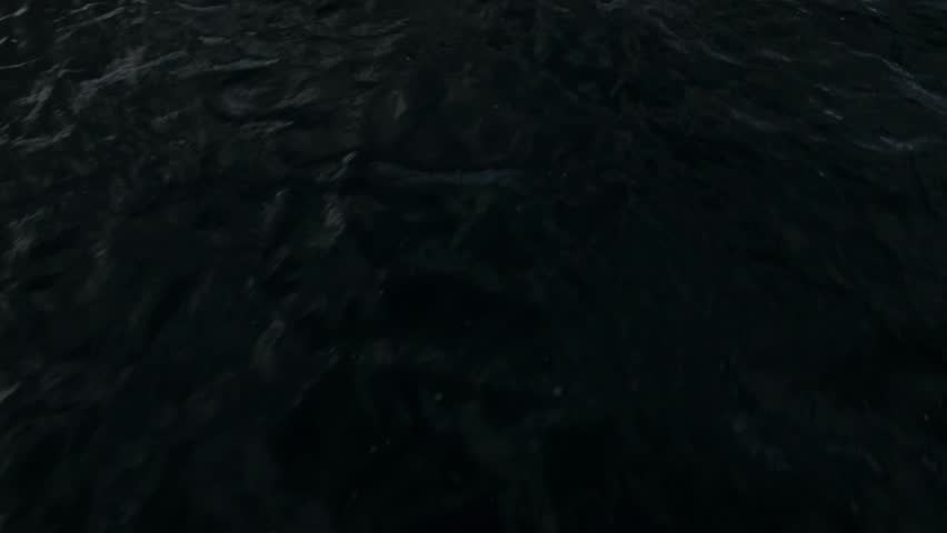 Aerial drone shot low flying over a lake to reveal a mountain range in Salt Lake City with fall-colored leaves at 60fps.