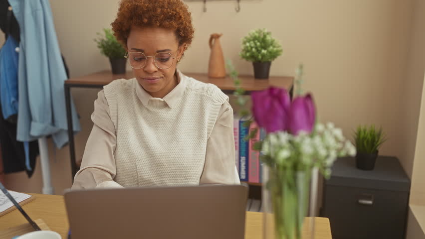 Insulting with style, laughing african-american woman sits at home, fingers crafting 