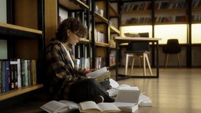 zoom in student girl with curly hair wearing glasses reads a book sitting on the floor among open books in the library - Powered by Shutterstock - Get 15% off with code: PIKWIZARD15