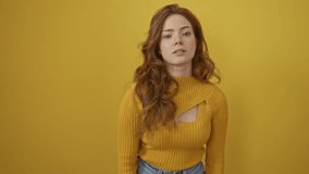 Young caucasian woman wearing sweater standing amazed and smiling to the camera while presenting with hand and pointing with finger. over isolated yellow background - Powered by Shutterstock - Get 15% off with code: PIKWIZARD15
