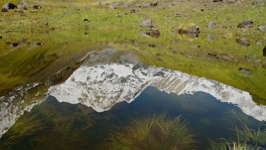 Snowcapped Mountains Reflecting Close Up, High Altitude Lake Reflection of Himalayas Mountains in Calm Still Water on Popular Trekking and Hiking Route of Annapurna Circuit in Nepal
