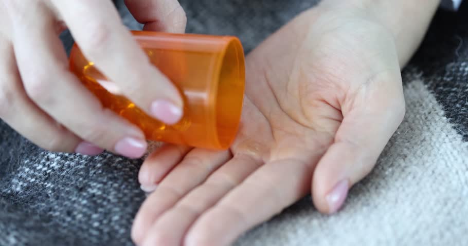Person pours medical pills fatty acids vitamins omega 3 on palm. Medical capsules yellow transparent color concept