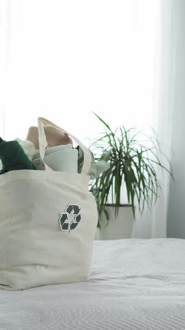 A large stack of folded clothes for recycling. The background is made of old clothes. the concept of sustainable fashion. Clothes for recycling. closed-loop economics. Taking care of the planet.