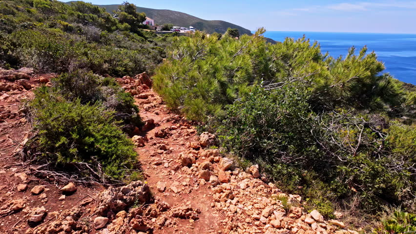 POV shot of a coastal rocky hiking trail in outdoors on Navagio Island