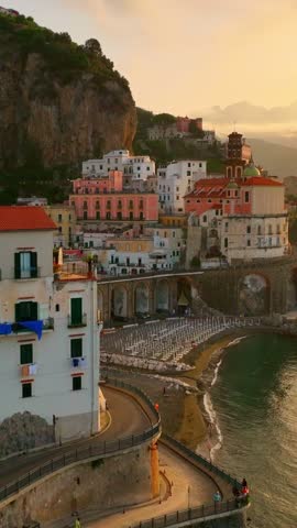 vertical video of sunrise at the Amalfi coast, aerial view of the coastal town of Amalfi and Atrani in Italy, famous seaside mediterranean town in Campagna, Italy, seacoast 
