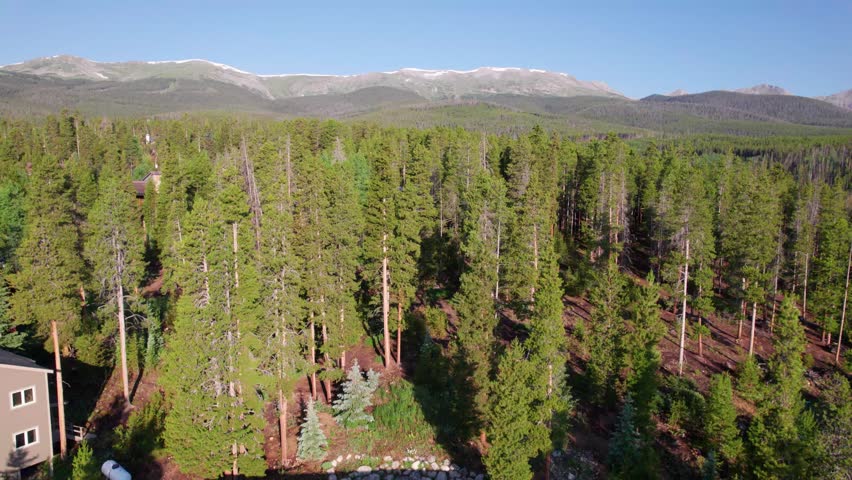 Aerial footage of mountains in Breckenridge Colorado. Camera rises to reveal more of the landscape.