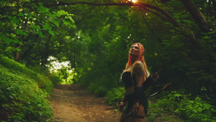 fantasy sexy woman queen walking along path dark dense forest enjoy sun light beam divine glow. Gorgeous Fairy Girl elf hunter archer rest relax calm chill listens to music sounds of wild nature. 4k