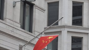 A flag of China hanging on an office building’s wall. - Powered by Shutterstock - Get 15% off with code: PIKWIZARD15