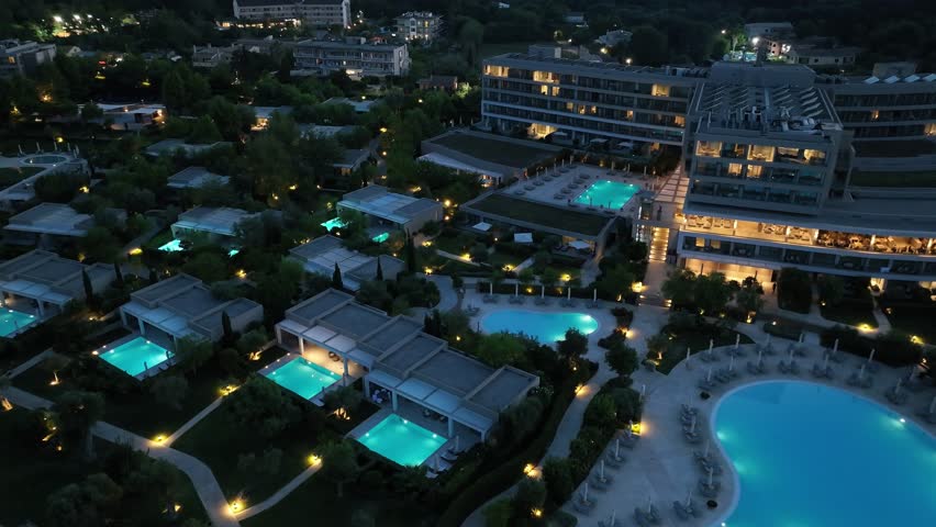 Resort with illuminated pool at night top down view