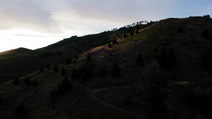 Aerial view of extreme terrain gravel road in mountains.