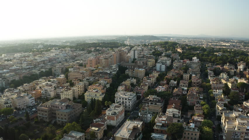 Panoramic aerial ascend above historic Trastevere neighborhood Rome Italy with sweeping views to horizon at sunset