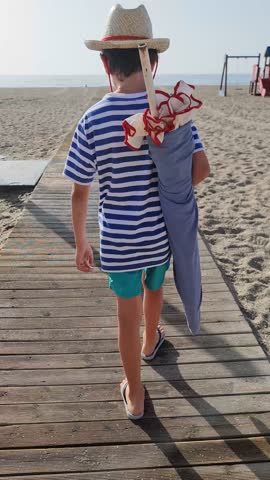 Happy boy walking to the beach during Summer Holidays