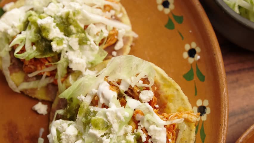 Corn toasts, chicken tinga, lettuce, sour cream, beans and green sauce