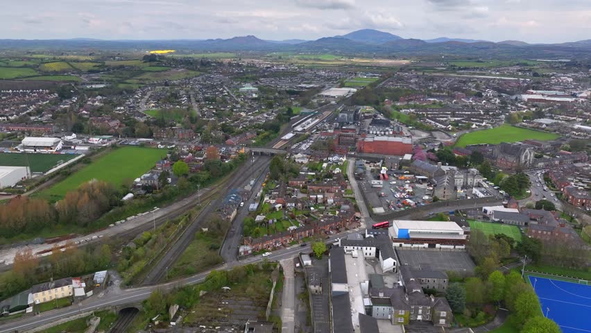 Dundalk, County Louth, Ireland, April 2023. Drone approaches Dundalk Railway Station with the Ring of Gullion and Mourne Mountains of Ulster and Northern Ireland in the distance.
