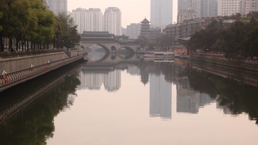 Chengdu capital city of the Chinese province of Sichuan, Anshun Bridge over the Jin river with modern skyline skyscraper building in background haze foggy day