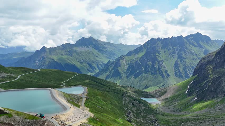 Aerial - turquoise alpine water reservoirs on mountain range, Austria