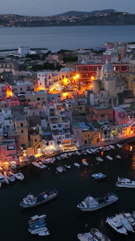 vertical aerial video of Procida island in Italy at night, Procida is an island near Naples with traditional fishing village in the bay of Naples. High quality FullHD footage