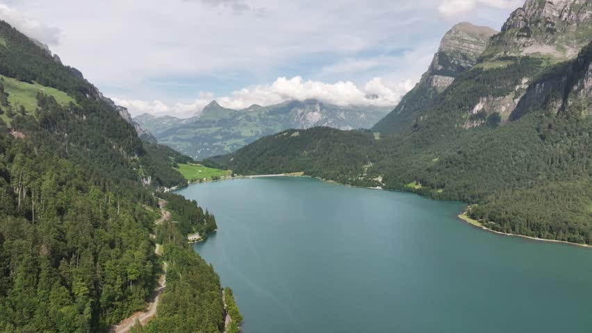 Demanding nature of the Klöntalersee lake surrounded by mountains and forests. Aerial view of Switzerland in summer.