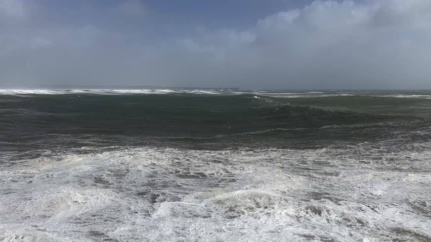 Large ocean wave swells come ashore after storm on wild sea coast