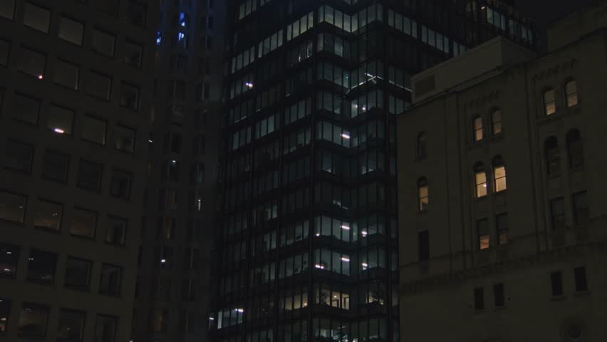 Breathtaking view of Toronto skyline with office buildings glowing late at night. The illuminated windows tell the story of a city that never sleeps, with work continuing well into the night.