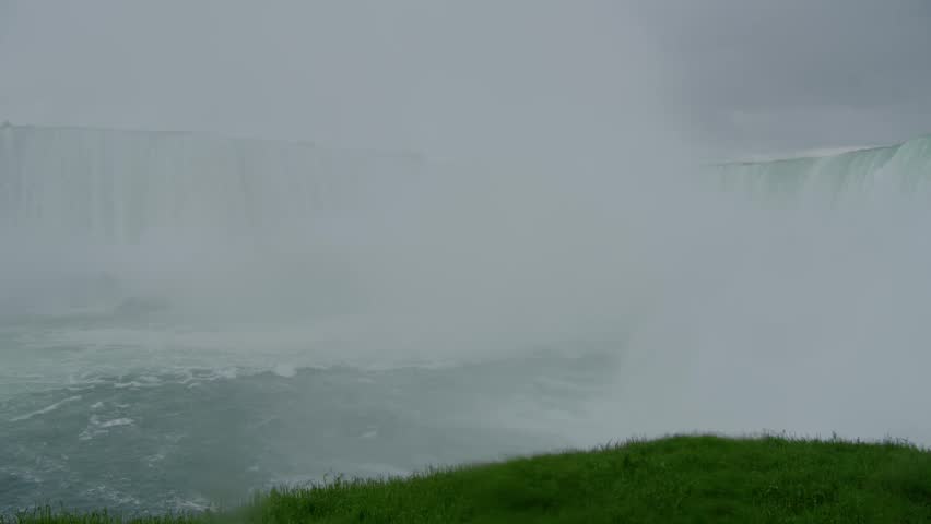The powerful flow of Niagara Falls in Canada, North America, seen from the Canadian side on a cloudy day. The grey skies add a mysterious and serene tone to this natural wonder.