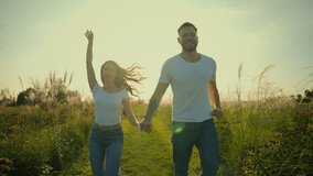 Happy laughing Caucasian lovers couple family bearded man male husband smiling woman wife female holding hands running together jogging having fun vacations outdoors sunny grassy farmland rural field - Powered by Shutterstock - Get 15% off with code: PIKWIZARD15