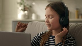 Little Caucasian girl headphones laptop computer technology web cyberspace listen music joy pastime home weekend leisure electronic device audio childhood dance earphones emotion enjoy fun happy smile - Powered by Shutterstock - Get 15% off with code: PIKWIZARD15