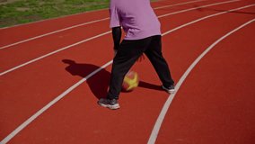 Athlete dribbling basketball on outdoor track in slow motion, showcasing footwork and shadow play under bright sunlight during training session - Powered by Shutterstock - Get 15% off with code: PIKWIZARD15