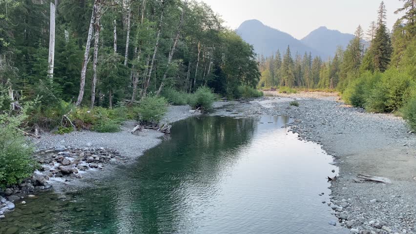 A beautiful afternoon view from a bridge on the Big Four Ice Caves Trail in Washington State around 5 PM. The video captures the serene valley landscape, highlighting the natural beauty.