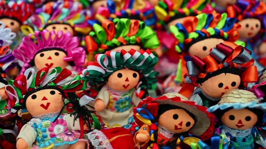 Colorful traditional Mexican rag handmade doll isolated in white. Doll with long braids and ribbons using the colors of the Mexican flag
