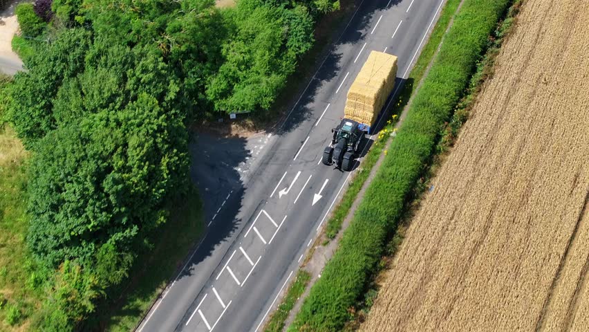 Tractor Moving Hay Bales During the Summer Harvest