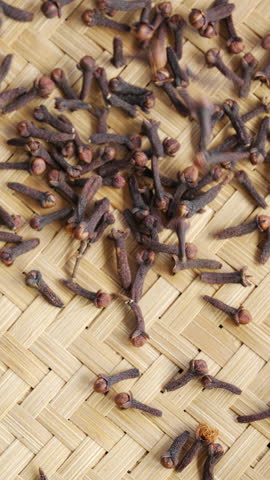 Dried clove buds falling in slow motion and rotating, aromatic flower buds, syzygium aromaticum
