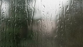 Raindrops are seen streaming down a window pane in a close-up view. The scene captures the detail of the rain droplets as they trickle down the glass. - Powered by Shutterstock - Get 15% off with code: PIKWIZARD15