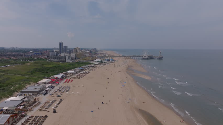 Aerial view of The Hague beach with pier, sandy shore, and tall buildings on a sunny day for tourism and travel themes