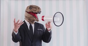 Politician in dinosaur mask creative costume on striped light backdrop makes PR noise speech in megaphone voice amplifier gesticulates promotes idea. Leadership team manager motivates employee to work - Powered by Shutterstock - Get 15% off with code: PIKWIZARD15