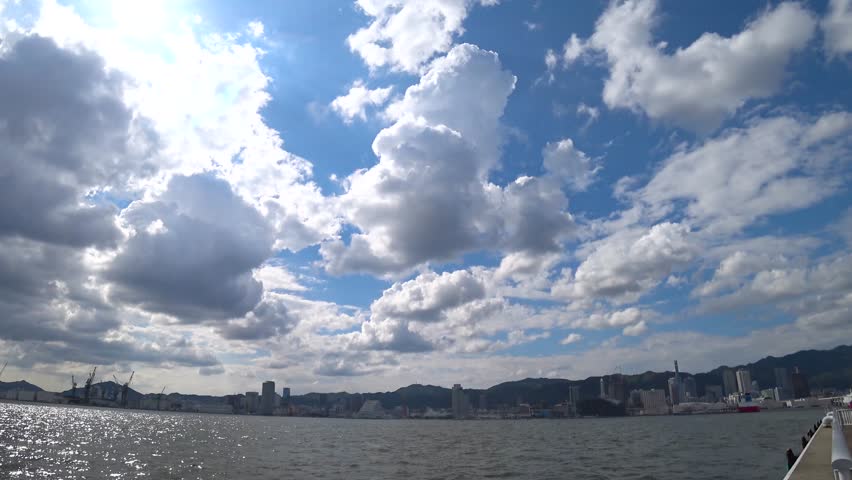 KOBE, HYOGO, JAPAN - JUNE 2024 : Scenery around Kobe port in daytime. View of buildings at Meriken park and Sannomiya downtown area. Travel and tourism concept video. 4K time lapse shot.