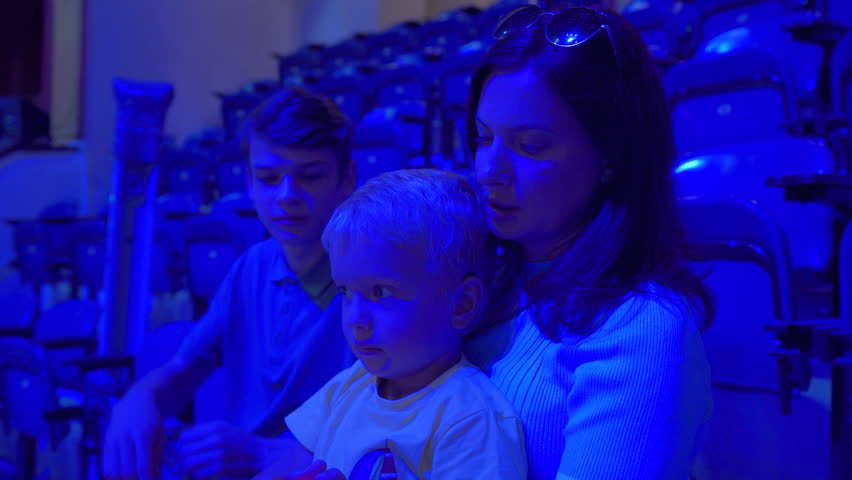 Spectators in a circus. Woman with children waiting for a circus performance to begin