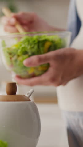 Portrait screen. Expecting a baby, expectant mother eats salad in the home kitchen. Pregnant housewife eats green salad with fresh vegetables, caring for her condition, woman prepared vegetable salad
