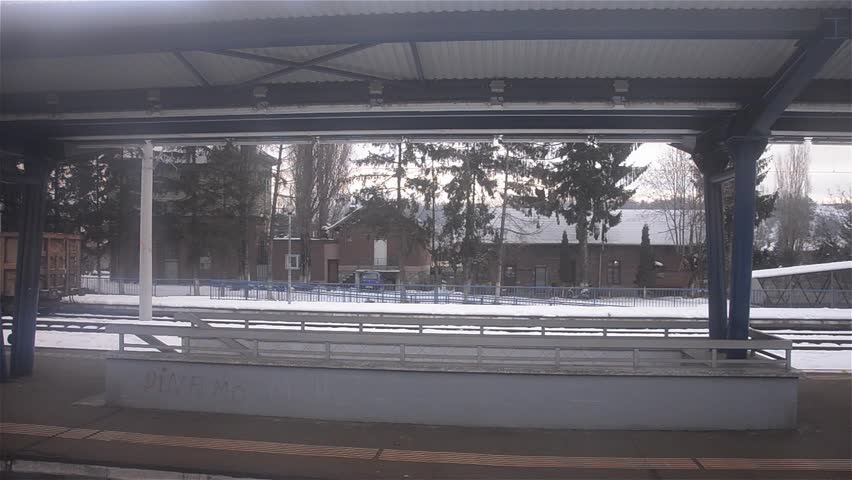 Train station viewed through a moving train in winter season
