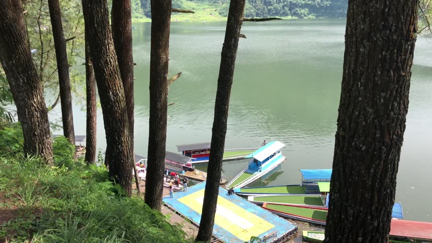 colorful boats are moored on the edge of Lake Menjer
