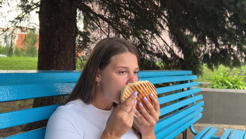 girl enjoys eating fast food, similar to the Turkish doner kebab.
