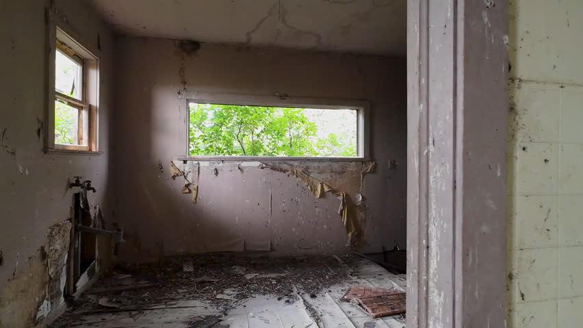 Aerial abandoned pioneer farm house kitchen down stairs. Old pioneer home building. Walls, floors, ceiling and room deteriorating falling apart. Built in late 1800