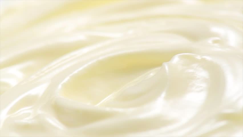 Sour cream or greek yogurt swirl, rotating texture, White cream background, close up. Dairy product. Delicious organic creamy yogurt. Milk cream. Macro shot. 