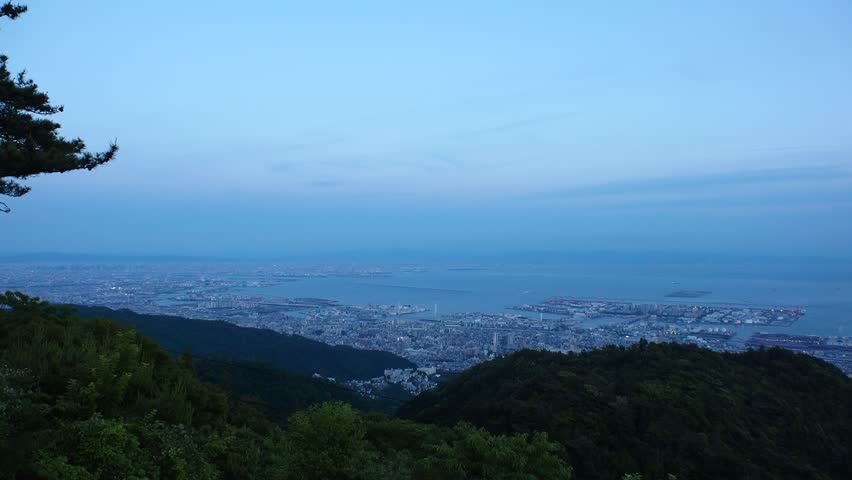 KOBE, HYOGO, JAPAN - JUNE 2024 : Aerial high angle panoramic view around Kobe city, Kobe port, Osaka city and Osaka bay in sunset time. View from top of Rokkosan (Mt. Rokko).