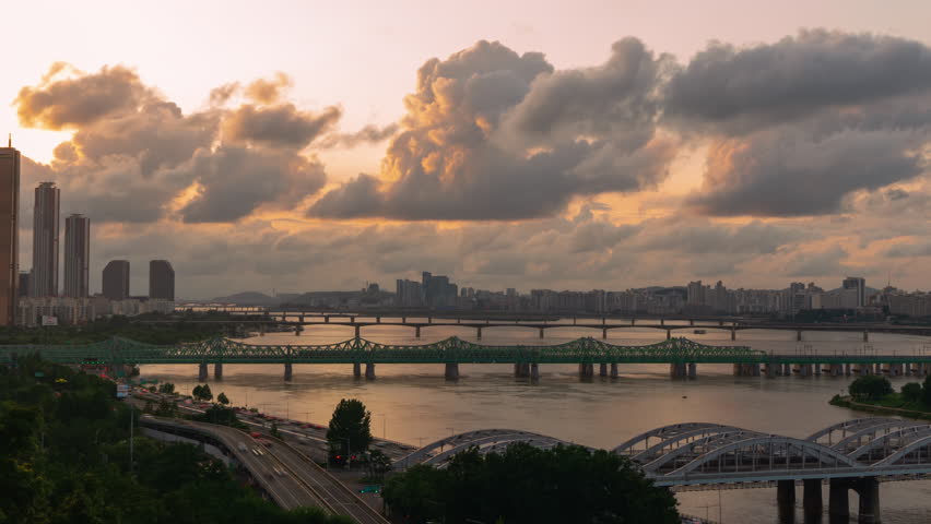 Beautiful Dramatic Sky Sunset Over Han River Overlooking Many Bridges, 63 Building and Car Traffic Time Lapse on Olympic Expressway, at Yeouido District in Seoul City, South Korea - zoom out