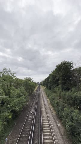 A South East London train line shows a train travelling along the tracks on its way out of town. Filmed from the bridge above 